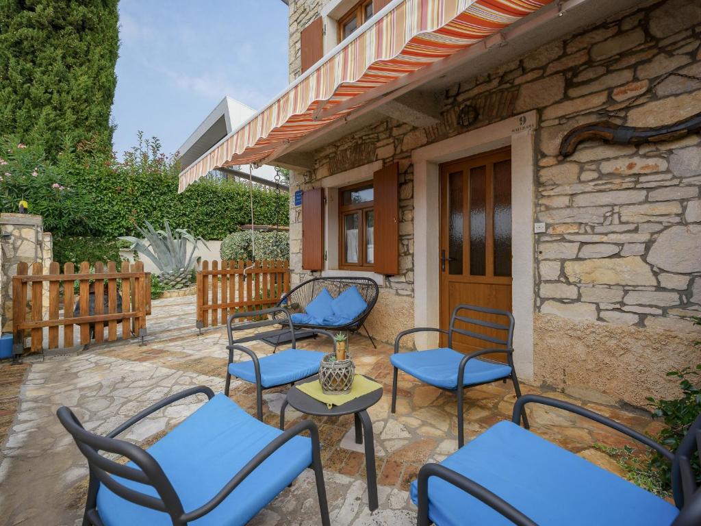 un patio avec des chaises et des tables ainsi qu'un bâtiment dans l'établissement Casa Astrid, à Poreč