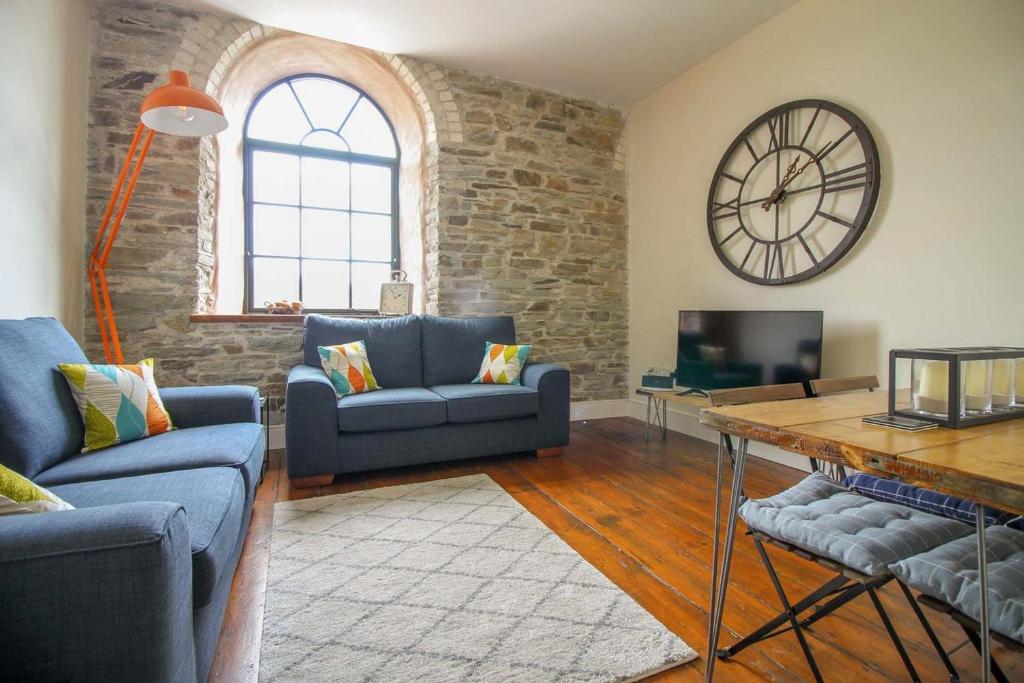 a living room with a large clock on the wall at The Old Carriage Works in Lostwithiel