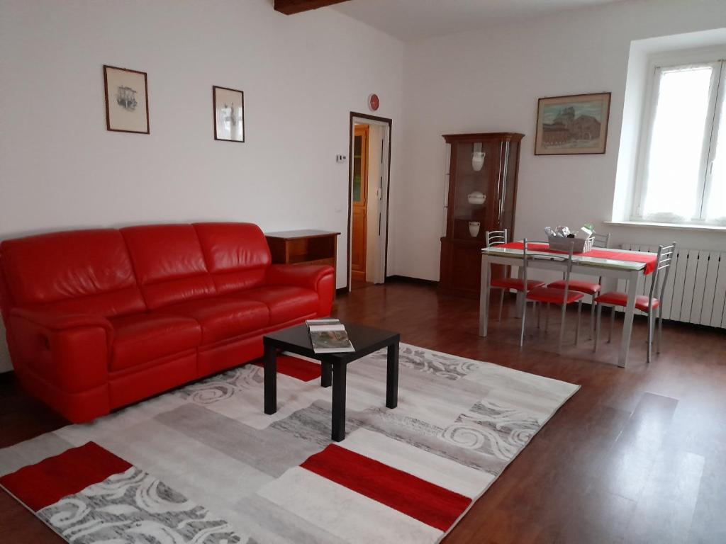 a living room with a red couch and a table at Domus Flavia in Mantova