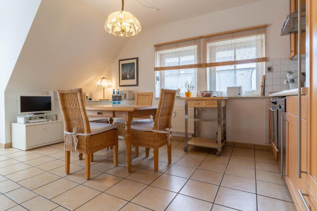 a kitchen with a dining room table and chairs at FeWo-Salzwiesen in Süderhöft