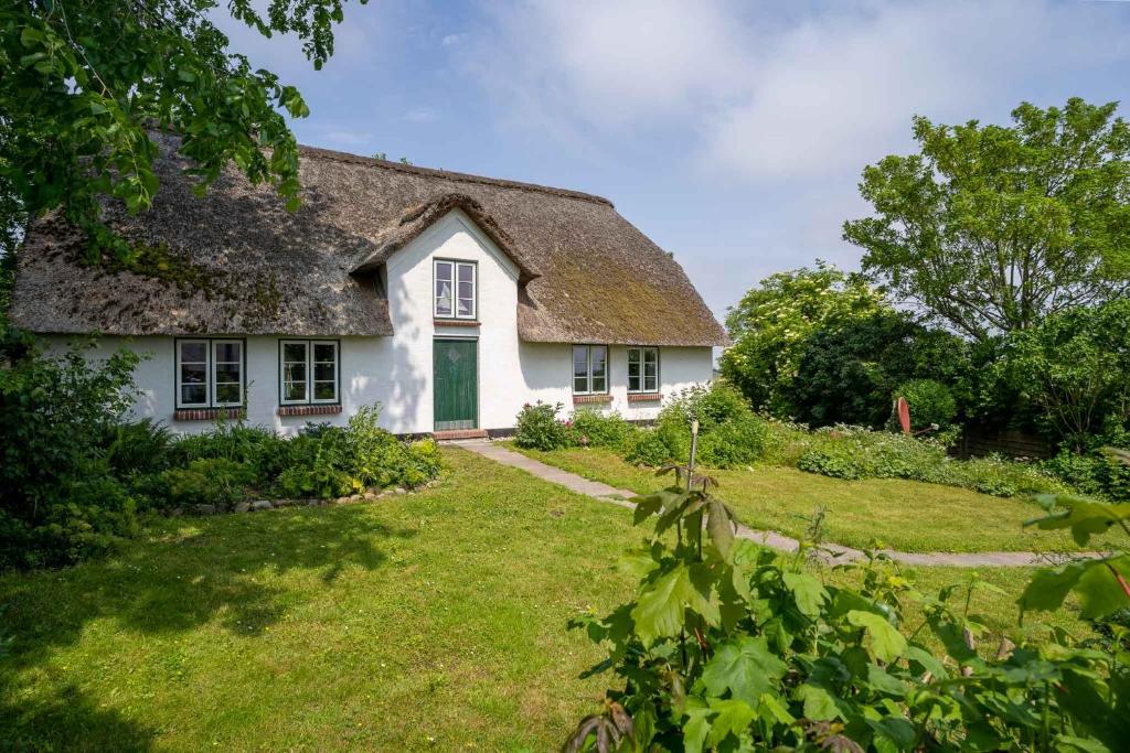 a white house with a thatched roof at HYGGE-unter-Reet in Westerhever