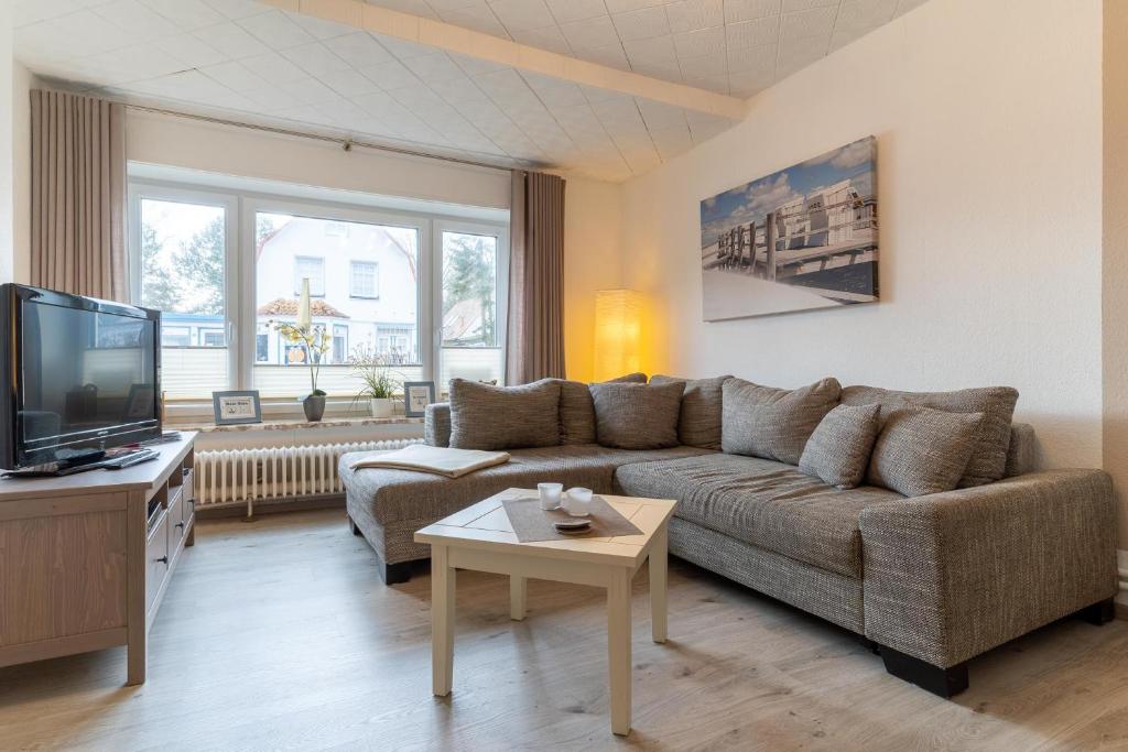 ein Wohnzimmer mit einem Sofa und einem TV in der Unterkunft Haus Springfloot, Whg. 1, EG in Olsdorf