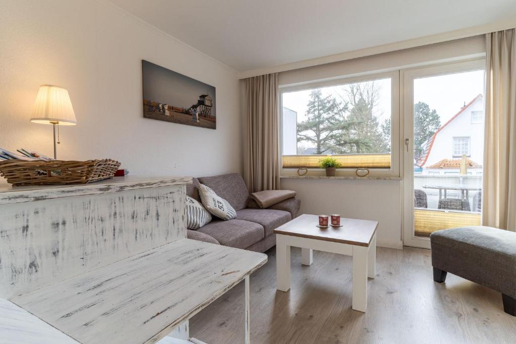 una sala de estar con un sofá y una mesa en Haus-Springfloot-Whg-3-OG, en Olsdorf