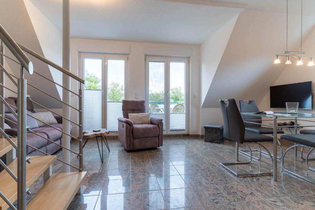una sala de estar con un escritorio y sillas en Haus-Eriel-OG-rechts, en Brösum