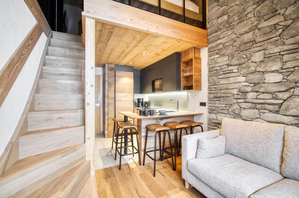 a kitchen and living room with a stone wall at Appartement 123 (RDP) in Tignes