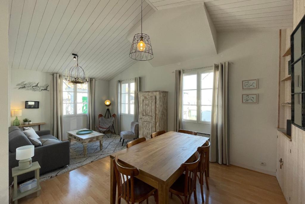 a living room with a table and a couch at Very bright nest with terrace in the village in La Flotte