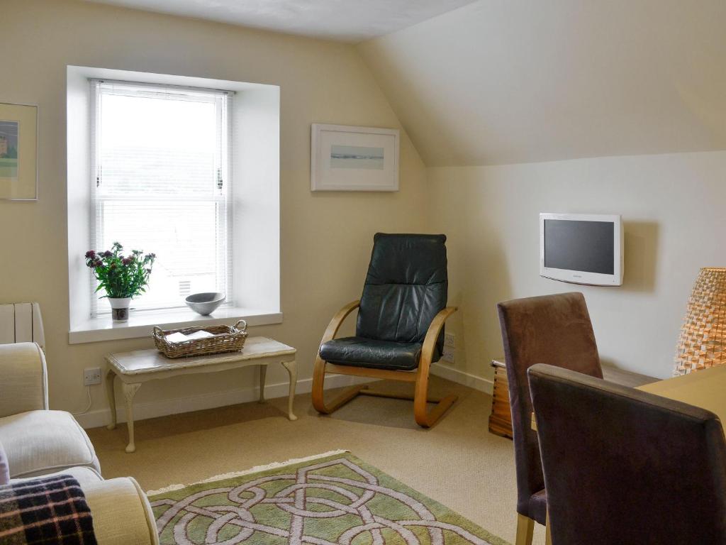 a living room with a chair and a tv at Kerloch View in Banchory