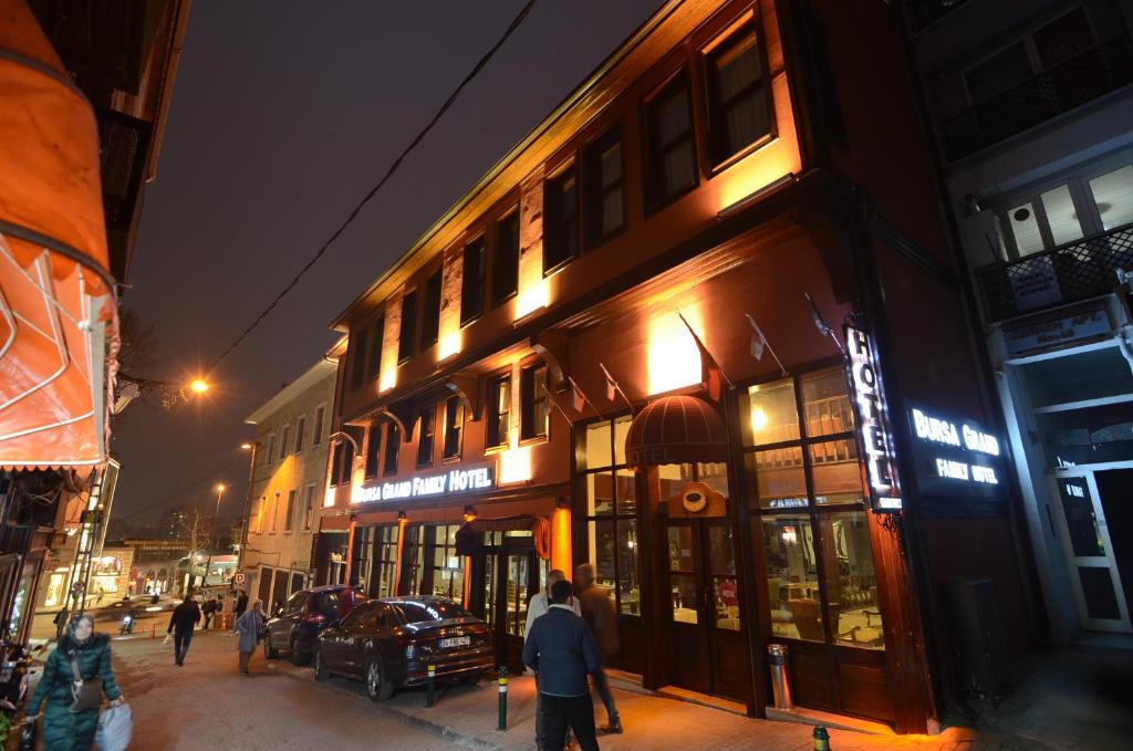 a group of people walking down a city street at night at BURSA GRAND FAMİLY HOTEL & SpA in Bursa