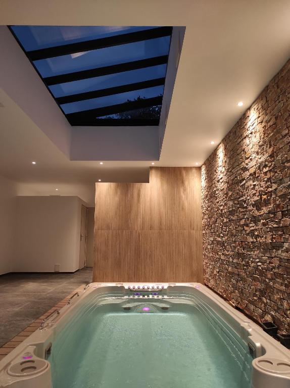 a hot tub in a room with a skylight at Appart hôtel & Spa La Villa du Port in Vannes