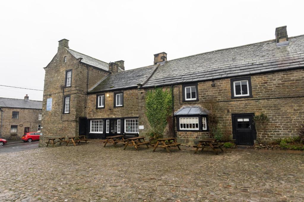 a brick building with picnic tables in front of it at The Ancient Unicorn in Barnard Castle