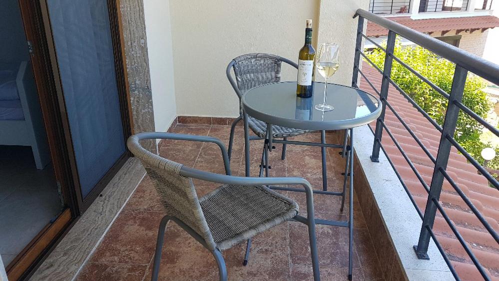 stół i krzesła na balkonie z butelką wina w obiekcie Villa Karolina - Halkidiki Kriopigi - 3 bedrooms w mieście Kriopigi