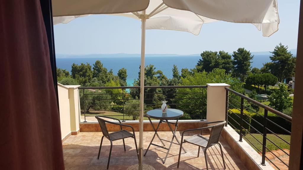 stół i krzesła na balkonie z parasolem w obiekcie Villa Karolina - Halkidiki Kriopigi - 3 bedrooms w mieście Kriopigi