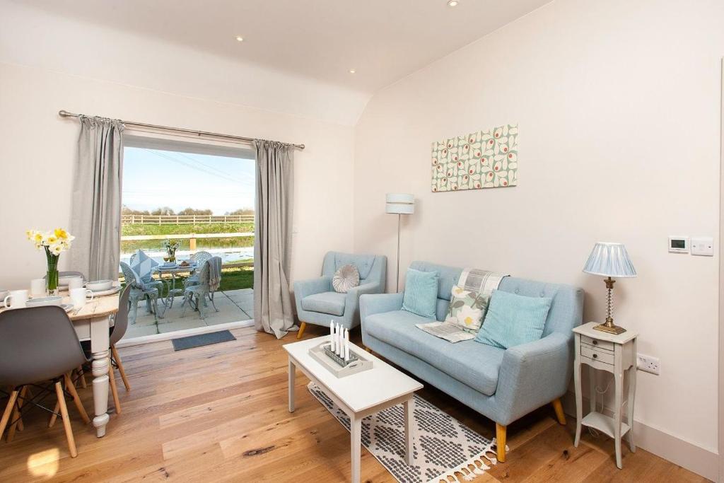 a living room with a blue couch and a table at The Dairy in Cricklade