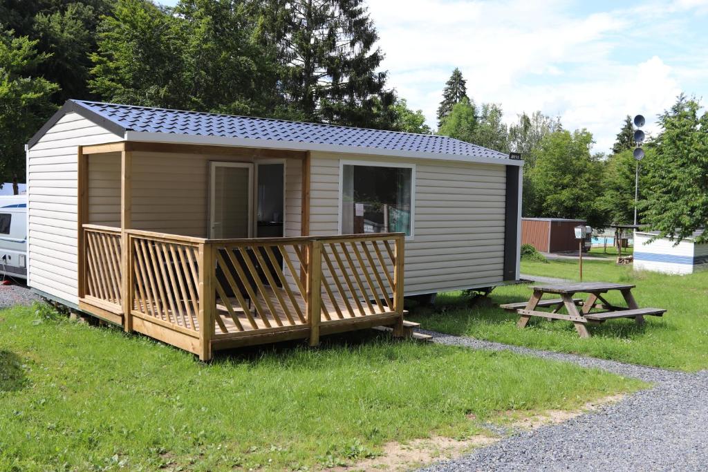 eine kleine Hütte mit einer Terrasse und einem Picknicktisch in der Unterkunft Cottage 