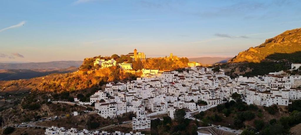 a group of white buildings on top of a mountain at Stylish 3 bed house 2 bathrooms with patio, roof terrace and communal pool 5 minutes away from the beautiful Spanish white village of Casares Pueblo and only 20 mins from the sea in Casares