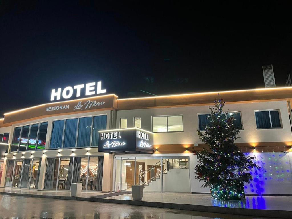 a hotel with a christmas tree in front of it at Hotel La More in Srebrenik