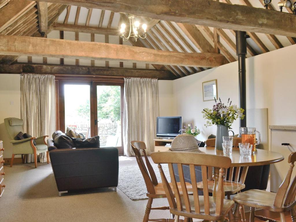 uma sala de estar com uma mesa e uma sala de jantar em The Carthouse em Malmesbury