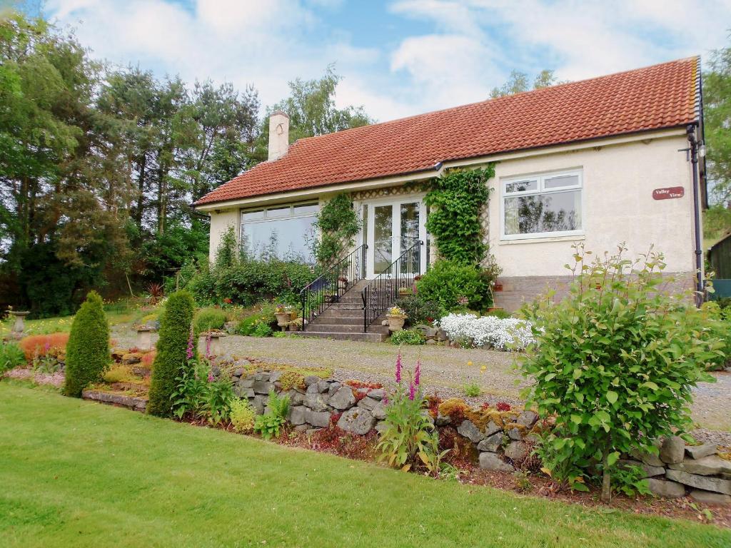 a house with a stone wall and a yard at Valley View Broughton in Broughton