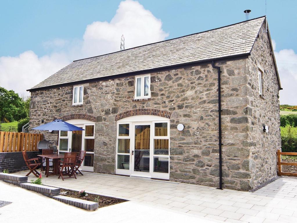 a stone house with a patio in front of it at The Coach House - Hw7593 in Bettws-yn-Rhôs