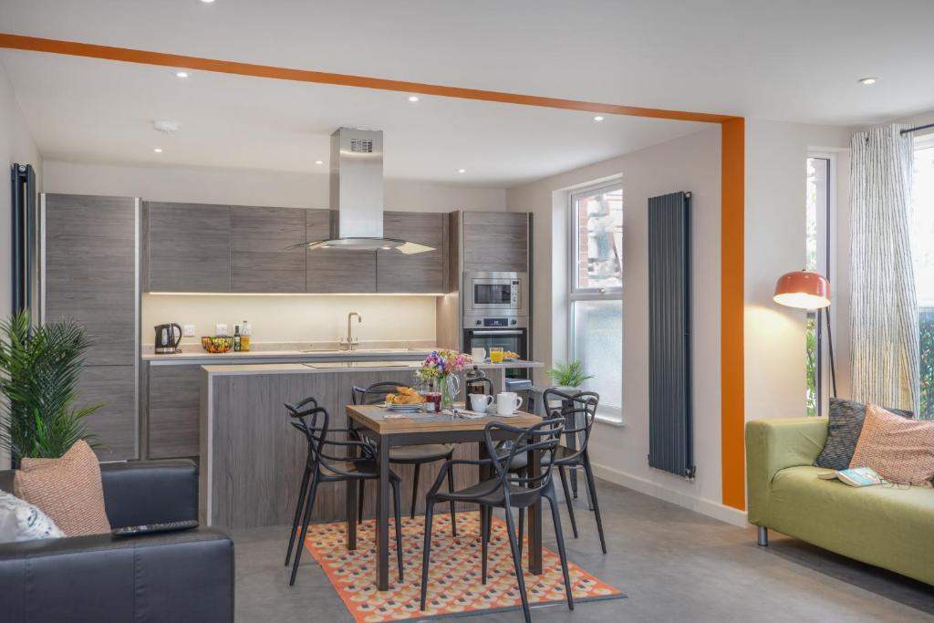 a kitchen and living room with a table and chairs at Apartment Three - Free Private Car Park - sleeps 6 - 3 shower rooms - by Ocean City Retreats in Plymouth