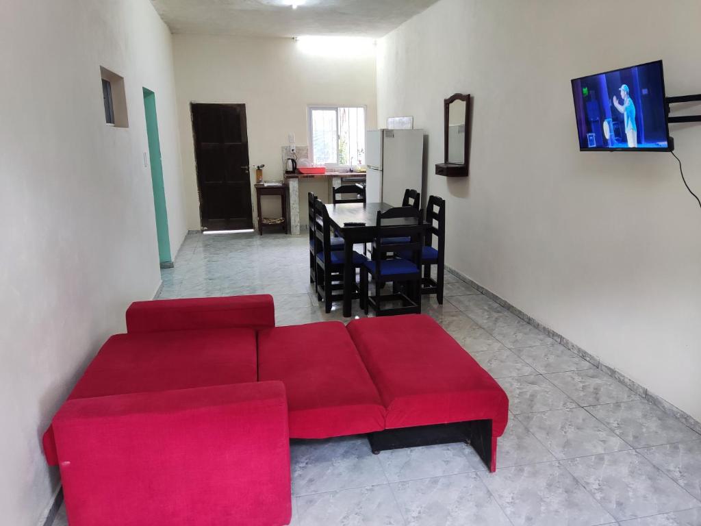 un soggiorno con divano rosso e tavolo di CASA EN CORRIENTES 2 HAB para 5 PERSONAS a Corrientes