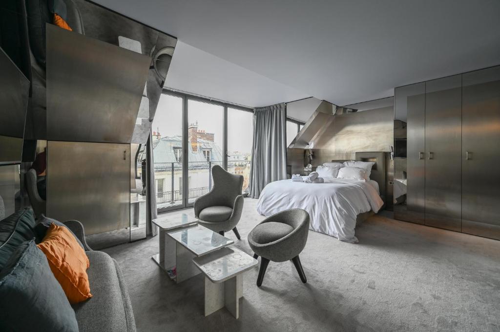 a bedroom with a bed and a chair and a table at Sublime Suite à saint Germain des Près (Montana 7) in Paris