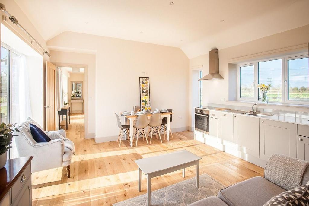 a kitchen and living room with a table and chairs at The Parlour in Cricklade