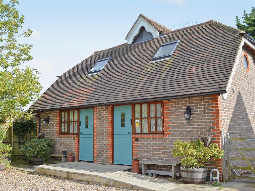 una pequeña casa de ladrillo con una puerta azul en Rose Cottage - 30502, en West Firle