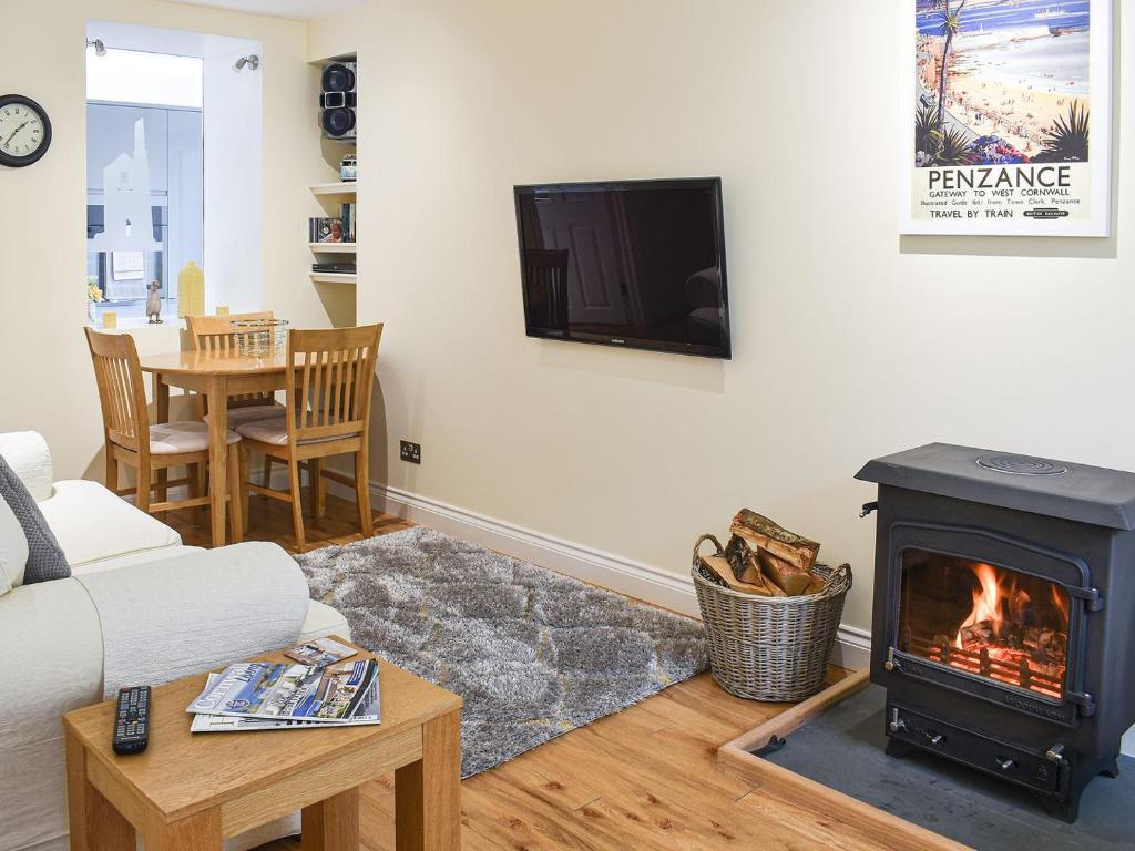 a living room with a fireplace and a tv at Jamaica Villa in Madron