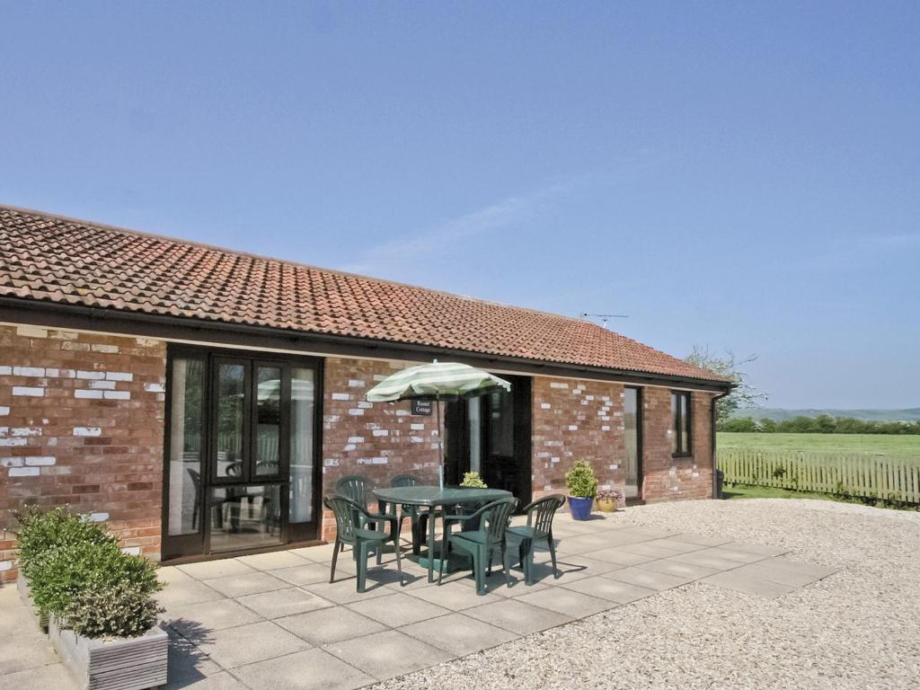 a patio with a table and chairs and an umbrella at Russet Cottage - E4678 in Brean