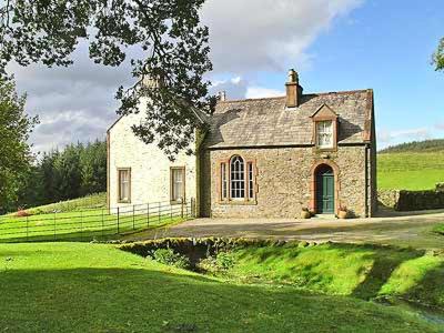 a large stone house in a grassy field at Marwhin House - Swwr in Kirkpatrick Durham