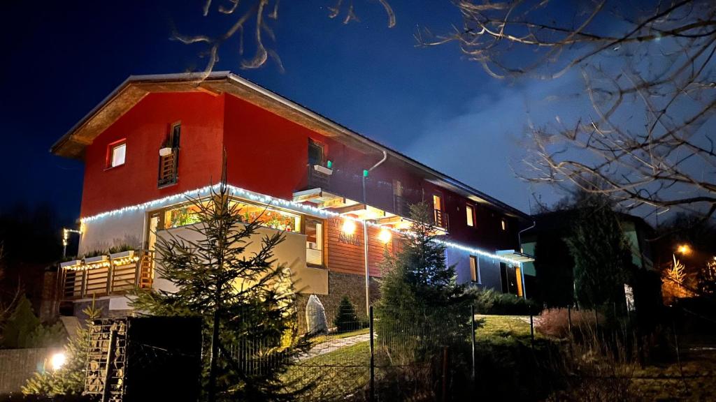 czerwony dom z oświetleniem w nocy w obiekcie Vila Anna w mieście Dolný Smokovec
