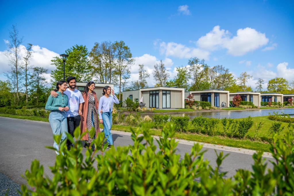 a group of people standing in front of a row of houses at Comfort Rooms by EuroParcs Buitenhuizen in Velsen-Zuid