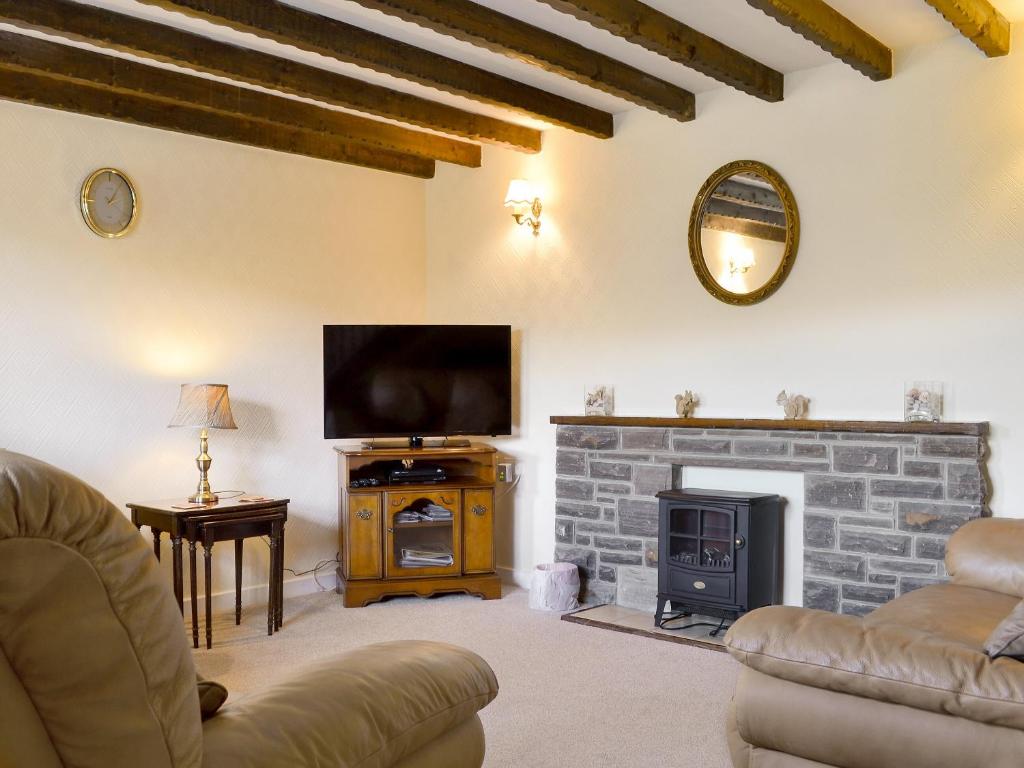 a living room with a tv and a fireplace at Riverview in Frosterley