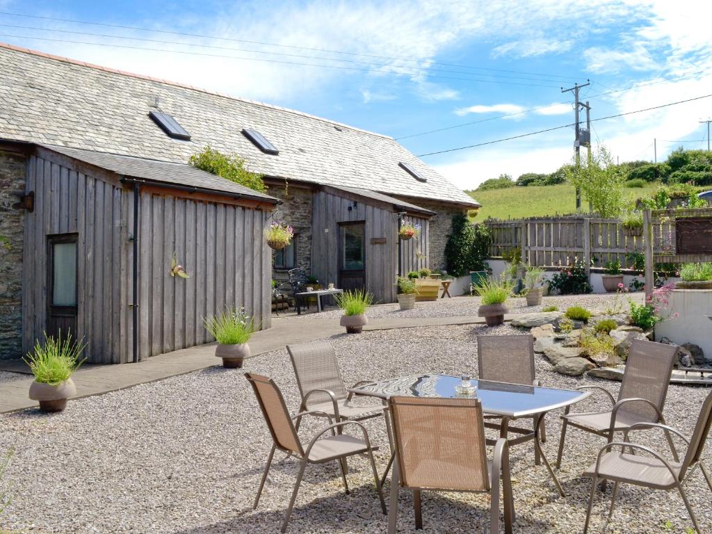 a patio with a table and chairs and a building at The Granary - Hkkw in Lynton