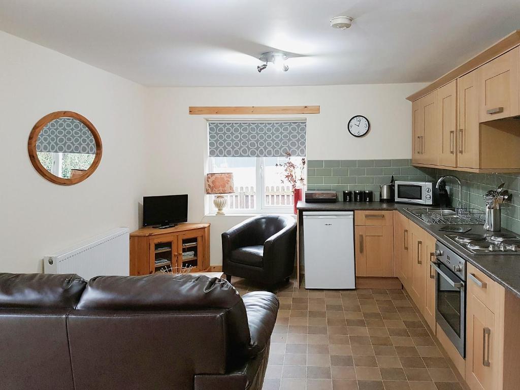 a living room with a couch and a kitchen at Fishermans Retreat in Old Leake