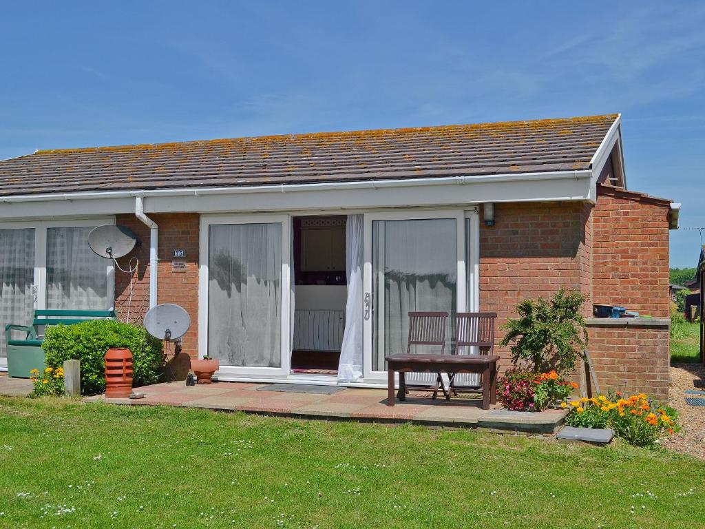 een stenen huis met een bank in de voortuin bij Dynamo Cottage in St Margarets at Cliff