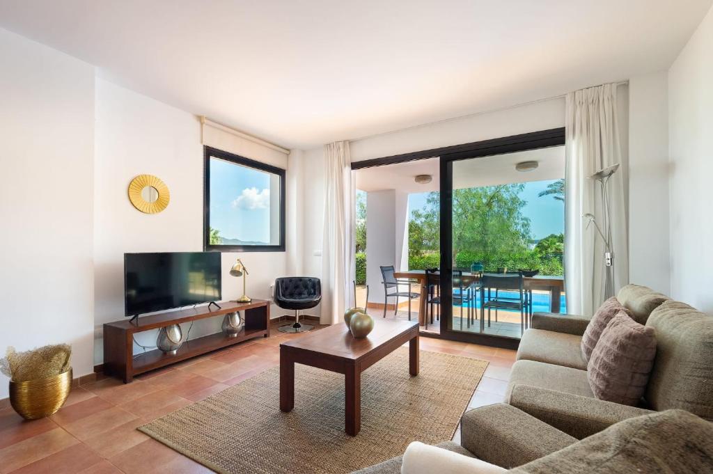 a living room with a couch and a tv at Can Terra con piscina in Sant Josep de Sa Talaia