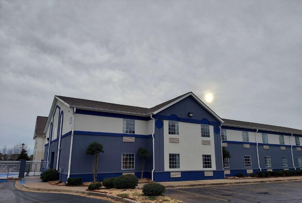 un edificio azul y blanco con aparcamiento en Days Inn & Suites by Wyndham Huntsville, en Huntsville