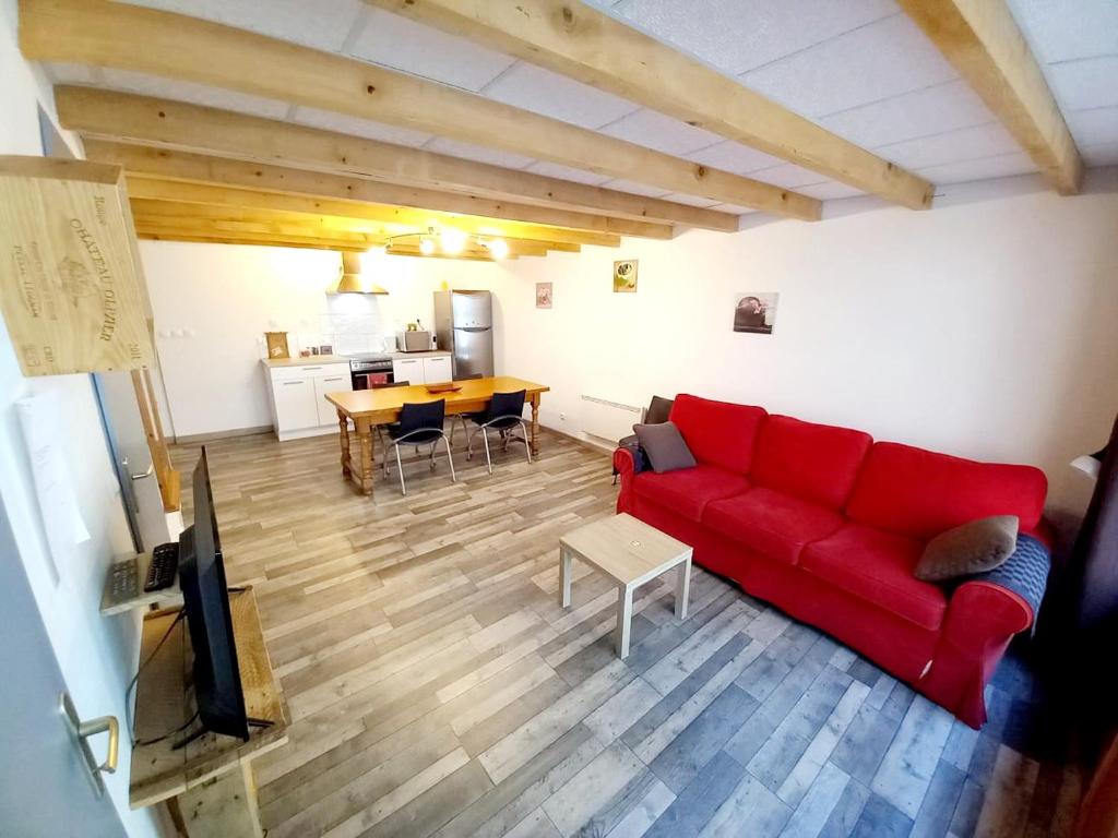 - un salon avec un canapé rouge et une table dans l'établissement Maison de ville au cœur du quartier historique, à Oloron-Sainte-Marie