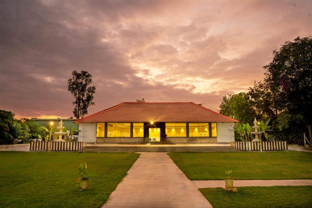 a house with a pathway in front of a yard at Farm Stay Resort - Shamirpet, Hyderabad in Hyderabad