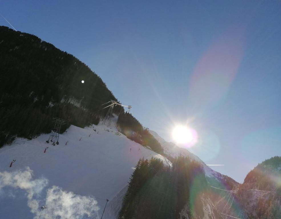 a view of the sun shining on a snow covered mountain at sonnberg in Ischgl