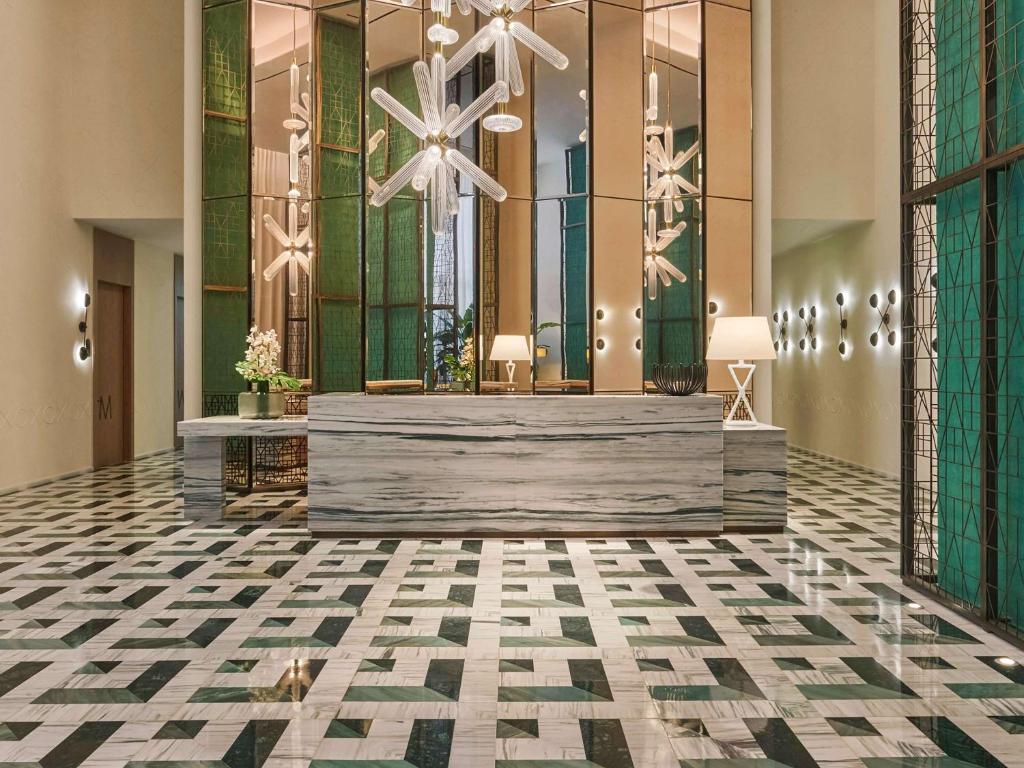 a lobby with a chandelier and ailed floor at SLS LUX Brickell in Miami