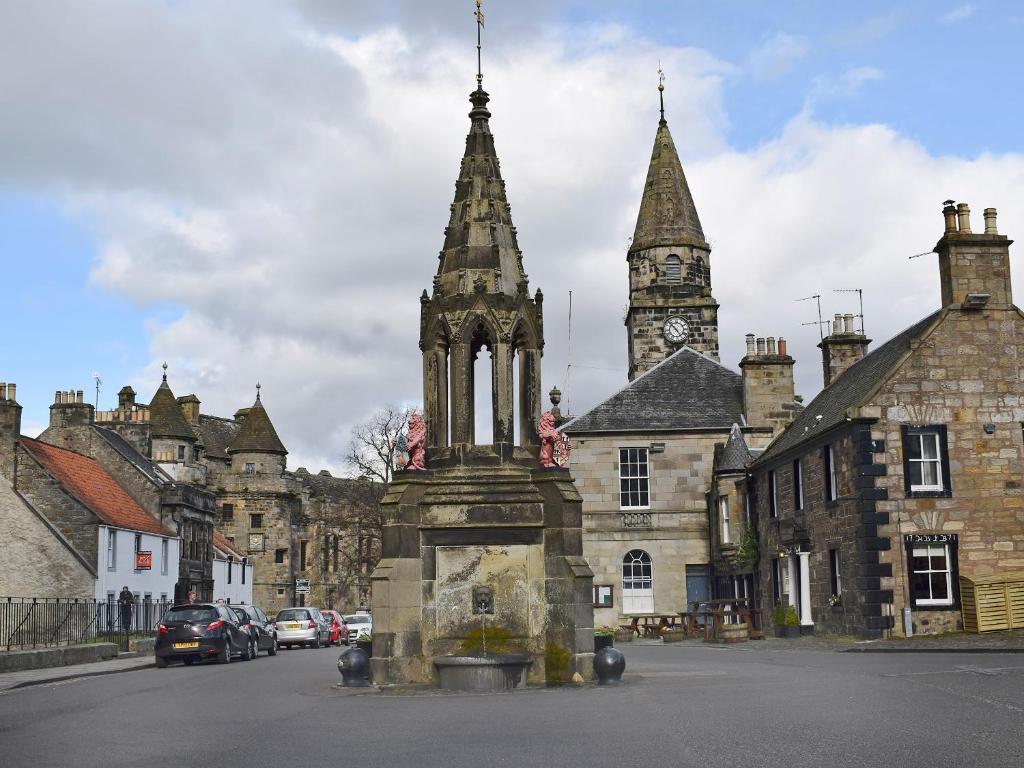 an old building with a clock tower on a street at Liquorstane - Uk40568 in Falkland