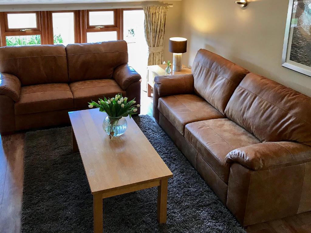 a living room with a brown couch and a coffee table at Stable Barn - 30954 in Thursford