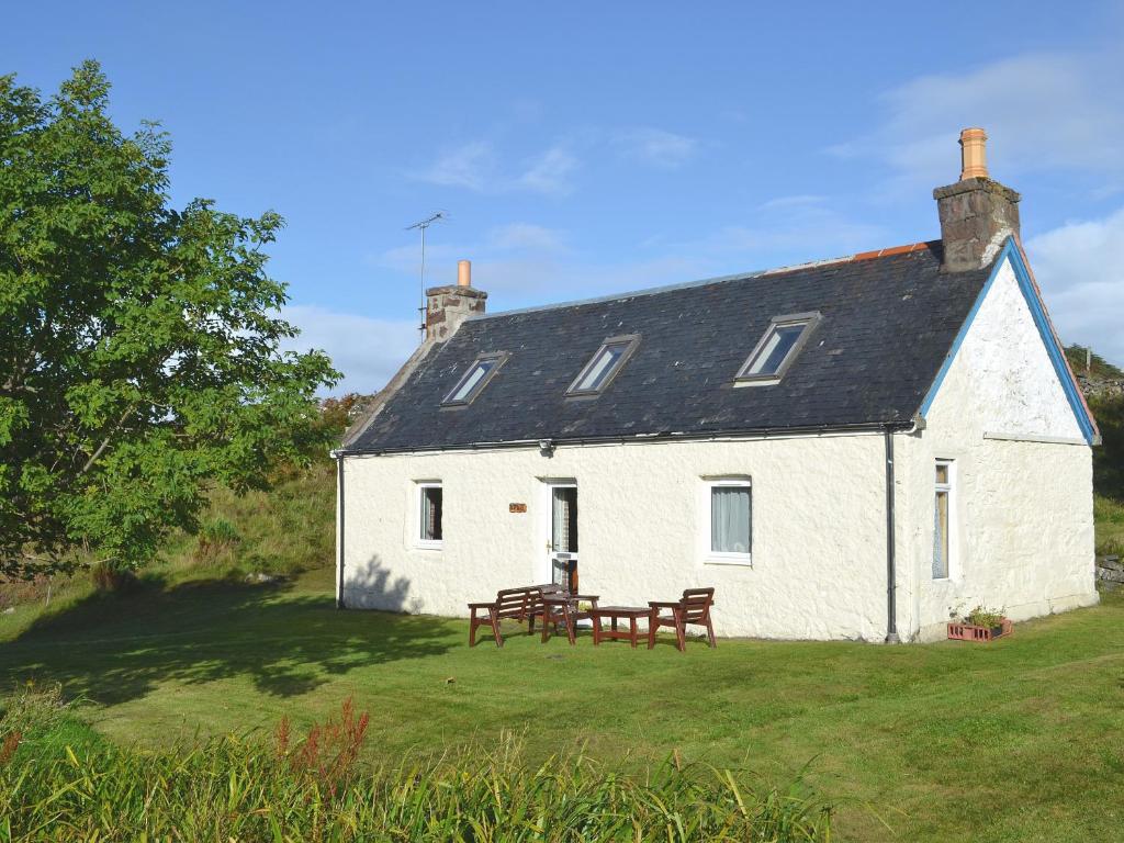 a white cottage with a picnic table in the yard at Achd in Nedd