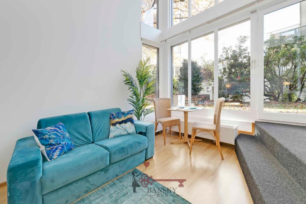 ein Wohnzimmer mit einem blauen Sofa und einem Tisch in der Unterkunft CENTRAL & BRIGHT Apartment on two floors 'TURQUOISE' -By EasyLife Swiss in Lugano