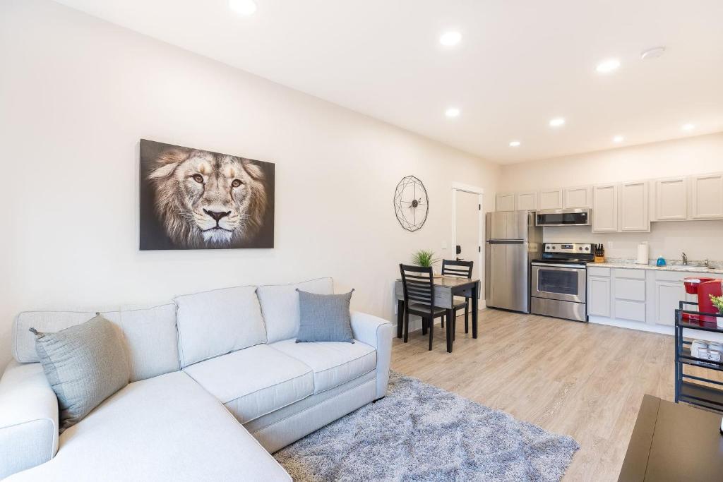 a living room with a white couch and a lion painting on the wall at Updated 2 Bedroom Apartment in Great Falls