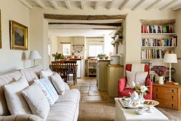 a living room with a white couch and red chairs at The Old Bakehouse Cotswold Cottage in Stonesfield