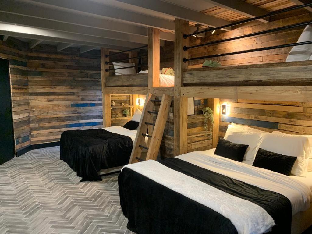 two bunk beds in a room with wooden walls at Sleepzzz in Heusden